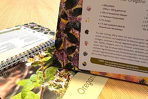 Rezeptbuch für Grillbrot mit Oregano, Inhaltsangabe und Tipps auf einer Holztischfläche.