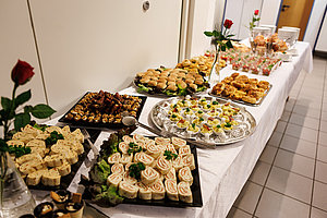 Buffet mit einer Vielzahl von Fingerfood, Snacks, belegten Brötchen und süßen Leckereien auf einem Tisch.