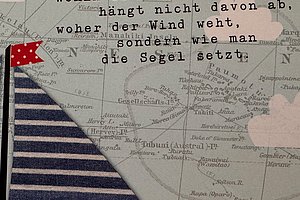 Segelboot mit gestreifter Segelfläche und rotem Wimpel vor einer Landkarte mit dem Text 'Wohin die Reise auch geht, hängt nicht davon ab, woher der Wind weht, sondern wie man die Segel setzt'
